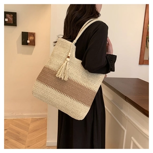 Detail of woven tote bag with color-block stripes, wooden beads and fringe tassel