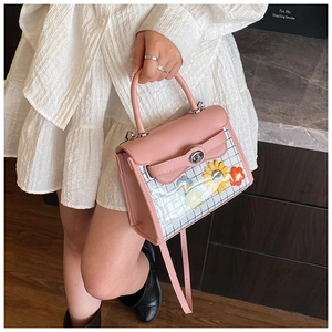 Close-up of pink square handbag with 3D sunflower details and clear plaid paneling