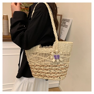 Detail of hand-woven straw bag with floral accents and bohemian cut-out patterns