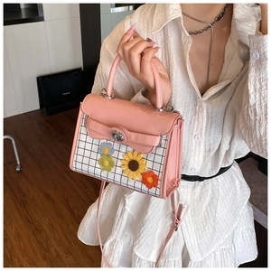 Pink PU leather handbag with floral accents and checkered pattern on white shirt