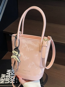 Sac seau en cuir rose marbré avec poignée supérieure et bandoulière sur escalier