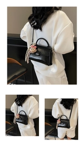 Détail du sac à main vintage en simili cuir noir avec rabat et breloque en peluche