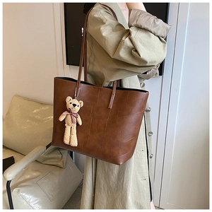 Borsa tote in pelle marrone con trama intrecciata e ciondolo a forma di orsetto decorativo