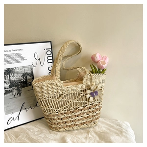 Detailed weave pattern of the straw tote bag with side bow charm and fabric lining