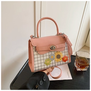 Detail of pink leather handbag with white checkered panel and handmade crochet flowers