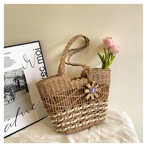 Close-up of a woven straw tote bag with purple petal charms and pink tulips for summer