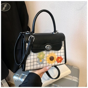 Detail of checkered square bag with sunflower embroidery and silver metallic twist lock