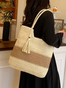 Large woven tote bag with neutral striped pattern and tassels for summer beach vacation