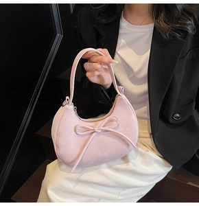 Détail du sac à main croissant rose avec texture suédine et élégante boucle décorative