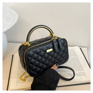 Close-up of black quilted PU leather crossbody bag with gold metal handle and chain
