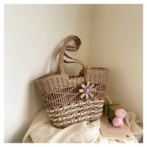Detailed close-up of a woven straw beach bag with a sunflower pendant and mesh texture