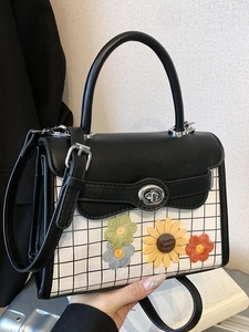 Elegant black leather handbag with floral embroidery and classic checkered pattern accent