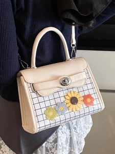 Elegant off-white crossbody bag with grid pattern and colorful crochet flower accents