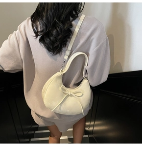 Vue détaillée du sac croissant crème avec nœud et boucle argentée ajustable