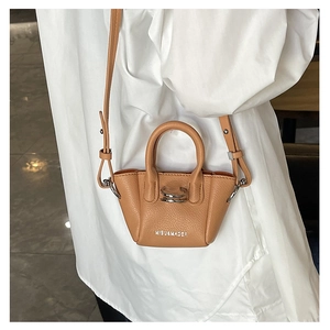 Dettaglio mini borsa in pelle martellata marrone con anello d'argento e tracolla