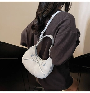 Détail du sac demi-lune bleu clair avec nœud 3D et bandoulière réglable pratique