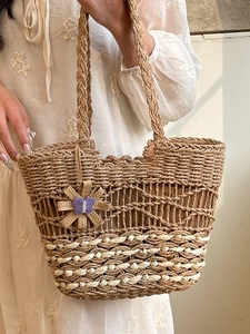 Handmade woven straw tote bag with wavy patterns and floral charm for summer beach vacation
