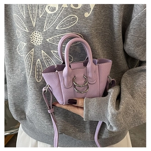 Dettaglio della mini borsa porta rossetto in pelle viola con anelli in metallo