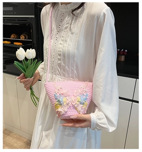 Detail der rosa geflochtenen Eimertasche mit 3D-Spitzenschmetterlingen und Perlen