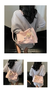 Detail of pink patent leather tote with silver chain strap and plush bear pendant