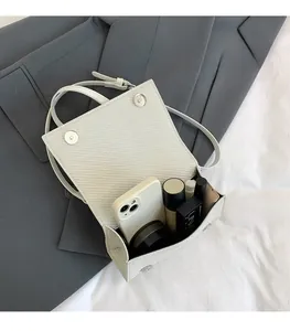 Vue de dessus du sac tissé blanc montrant l'intérieur spacieux pour maquillage et mobile