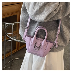 Dettaglio mini borsa in pelle litchi viola con anelli in metallo e logo MISU&MADER