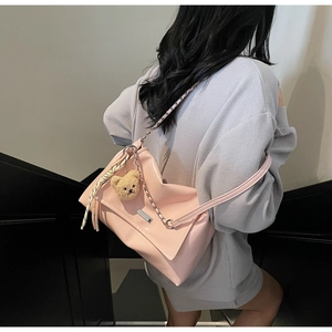 Detail of pink soft leather tote bag with chain strap and cute bear charm pendant