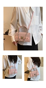 Détail du sac bandoulière rose avec boucle cœur, décor de chaîne et cuir à texture sergée