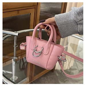 Dettaglio della mini borsa rosa in pelle martellata con decorazione a doppi anelli