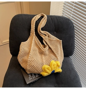 Detailed texture of beige woven tote bag featuring a large yellow crochet flower accent