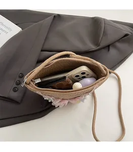 Detailansicht der gewebten Strohtasche mit rosa Blumen und Perlenverzierungen