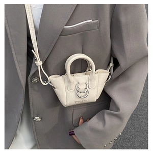 Dettaglio mini borsa a tracolla bianco crema con trama litchi e decoro con anelli