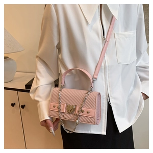 Détail d'un sac carré rose en cuir PU avec fermoir coeur en métal et bandoulière chaîne