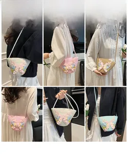 Detailansicht der handgefertigten Strohtasche mit Spitzenschleife in Pastellfarben