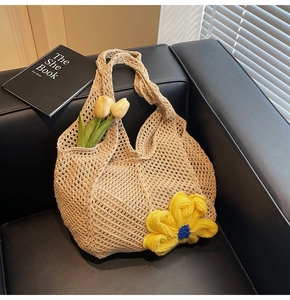 Detail of hand-woven hollow tote bag featuring a bright yellow floral crochet ornament
