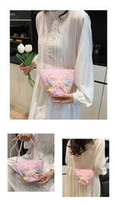 Detail der rosa geflochtenen Eimertasche mit 3D-Schmetterlingen und Kunstperlen