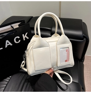 Close-up of a cream Boston bag with a transparent card pocket and silver hardware