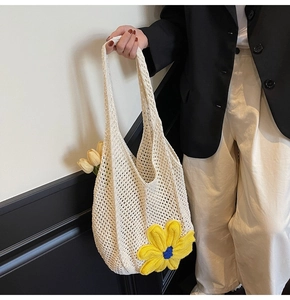 Close-up of cream woven mesh tote bag featuring 3D yellow daisy floral decorations