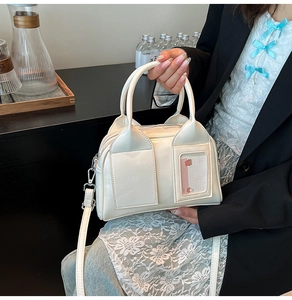 Detail view of white glossy leather pillow bag with cat-ear handles and card holder
