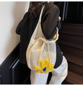Close-up of cream woven tote bag featuring a yellow sunflower charm in a casual style