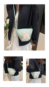 Detail der hellblauen gewebten Beuteltasche mit floralen Applikationen für den Sommer