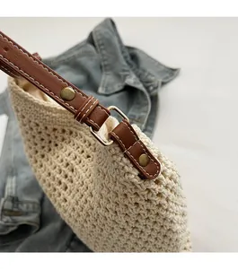 Close-up of woven tote bag edges with brown leather straps and precise stitching details