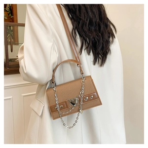 Vue détaillée du sac tissé marron avec boucle en cœur argentée et chaîne chic