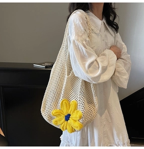 Close-up of handmade woven tote bag with a large yellow crochet flower and mesh pattern