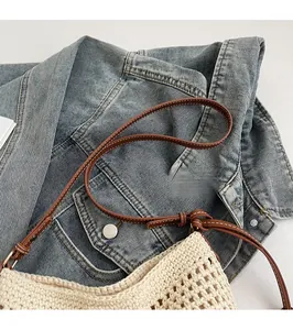 Detailed macro view of woven tote bag texture with brown leather strap and stitching