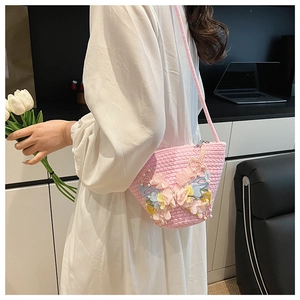 Nahaufnahme der rosa geflochtenen Beuteltasche mit 3D-Schmetterlingen und Blumendetails