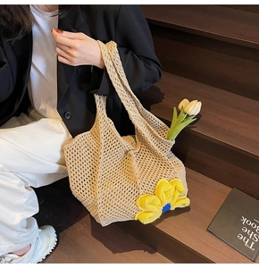 Detailed close-up of beige crochet tote bag featuring a large yellow 3D knitted flower decoration