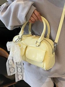 Minimalist light yellow patent leather Boston bag with side lace bow and pearl charm
