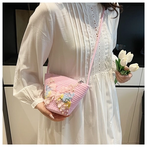 Detailansicht der rosa geflochtenen Beuteltasche mit 3D-Spitzen-Schmetterlingen und Perlen