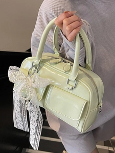 Glossy Boston bag in light green patent leather with a lace pearl bow charm